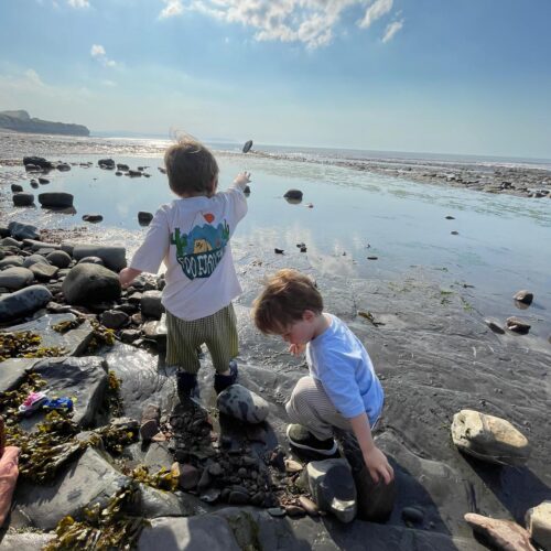 Two boys rock pooling at Klive beach